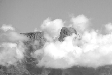 The distant imposing basalt cliffs of the Drakensberg mountains peaking above the cloud cover