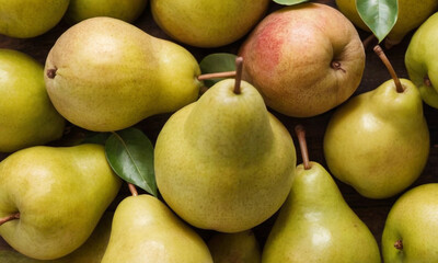 Various apples and pears tightly packed together, with both green and red apples and green pears visible, all having their stems intact.