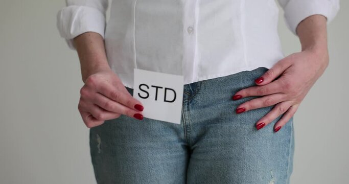 Woman showing STD sign and holding genitals. Sexually transmitted diseases caused by parasites in women