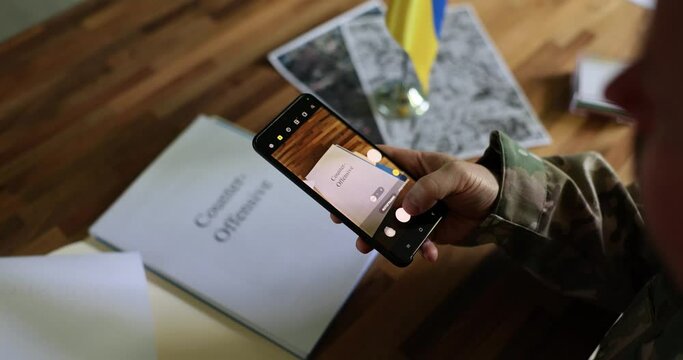 Military photographs on phone a document with inscription top secret and counteroffensive war between Ukraine and Russia. Ukraine's counteroffensive, betrayal and military data leak