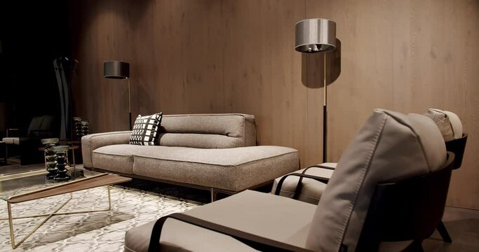 Modern gray and beige fabric sofa. Textile upholstery sofa with pillows. Modern apartment beautiful beige sofa in modern living room with lamp and carpet, table. Scandinavian interior with wooden wall