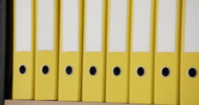 Yellow folders with folders and documents in long rows on shelves. Organized folder structure and archive