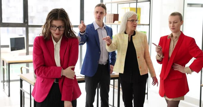 Frustrated tired female employee feels stressed, suffers from bad attitude and discrimination of colleagues. Business people group blaming female student colleague for incompetence gender inequality
