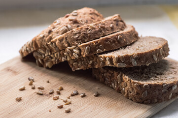 Sliced rye bread with sunflower seeds on wooden cutting board
