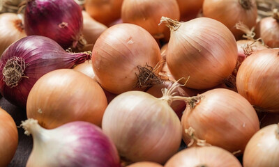 A collection of onions, including red/purple onions, white onions, and classic brown/yellow onions. The skins on some of the onions are slightly peeled revealing their layers.