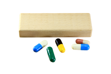 Empty wooden block for text or message short word english letter with capsule pills on brown wood pantern background.Copy space.