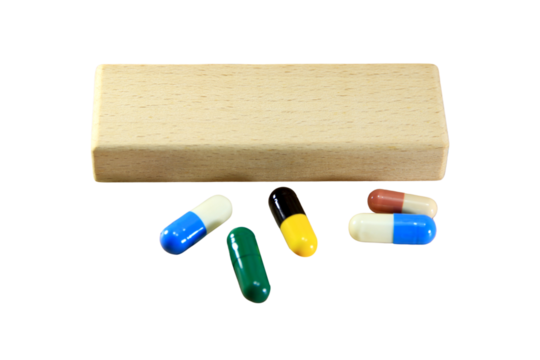 Empty wooden block for text or message short word english letter with capsule pills on brown wood pantern background.Copy space.