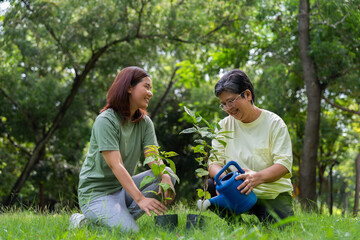 Old Asian Women and daughter join as volunteers for reforestation, earth conservation activities for reduce global warming growth feature and take care nature earth. Environment Concept