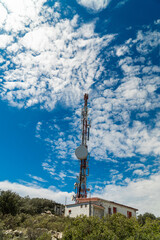 Obraz premium Communications tower on a mountain, signal repeater, sunny morning day.