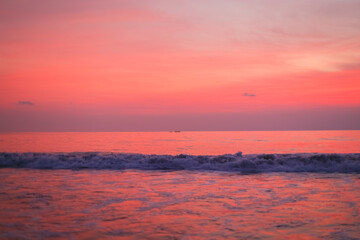 A bright pink sunset over the ocean. Beautiful sunset sky and ocean background