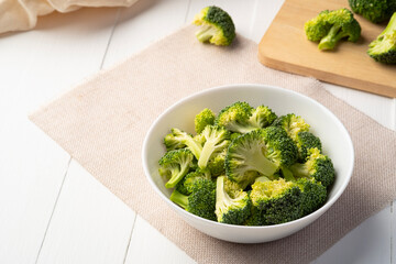 sliced broccoli in white bowl on the table,edible green plant in the cabbage family,whose large...