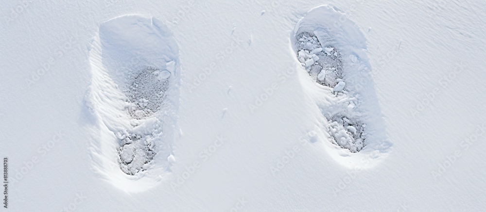 Wall mural empty copy space image depicting two shoe prints on freshly fallen snow seen from a top view