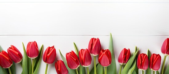 Top view of a Mother s Day background featuring a row of red tulips on a white wooden surface with ample space for content placement