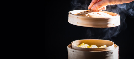 The dumpling in a bamboo steamer basket in a dim sum restaurant.