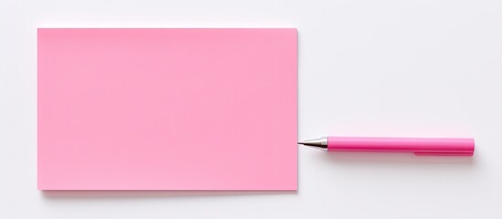 A pink sticky note and a pen arranged on a white background with blank space for images. Copy space...