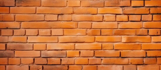 Obraz premium An orange brick wall with a textured surface perfect for wallpaper with ample copy space image