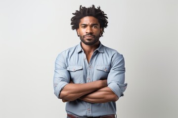 Obraz premium Portrait of a tender afro-american man in his 30s with arms crossed in white background