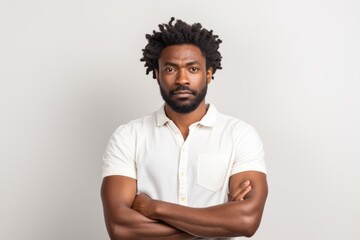 Obraz premium Portrait of a tender afro-american man in his 30s with arms crossed isolated in white background