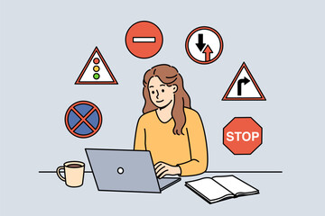 Woman studies traffic rules via laptop, preparing to take theoretical exam to obtain driver license. Girl student sits among road signs, studying traffic rules laws for car drivers