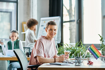 Cheerful woman engrossed in work, with phone, with her diverse colleagues on backdrop.