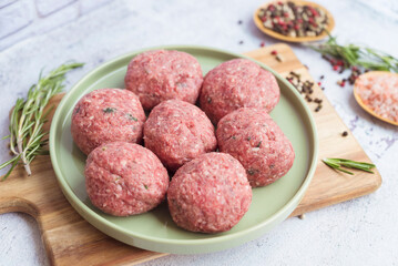 Beef raw meatballs on wooden background 