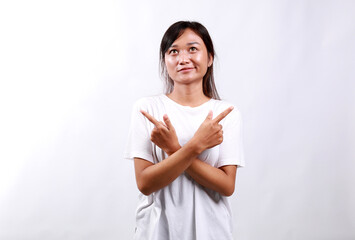 Indecisive asian woman standing pointing fingers sideways, pointing fingers and looking clueless,...