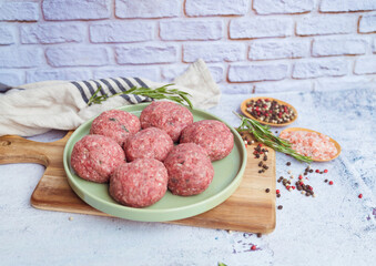 Beef raw meatballs on wooden background 