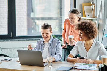 Diverse group of hard-working businesswomen collaborating around a table with a laptop.