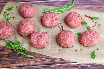Beef raw meatballs on wooden background 