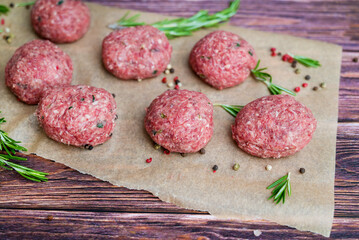 Beef raw meatballs on wooden background 
