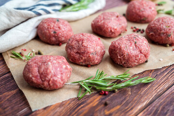 Beef raw meatballs on wooden background 