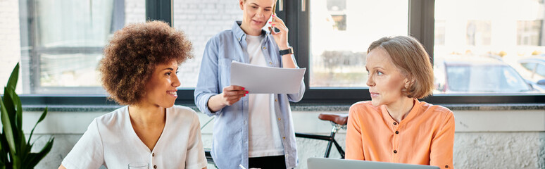 A diverse group of hardworking businesswomen sit around a table, engaged in a discussion.