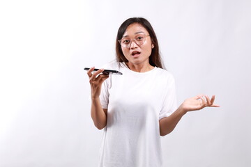 Confused young asian woman asking and shouting at mobile phone, looks outraged, furious while...