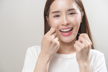 Flossing teeth, dental care hygiene concept, asian young woman flossing teeth with dental floss, smile happy with perfect white teeth, using tooth floss cleaning, healthy teeth isolated on background.