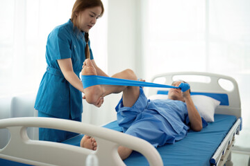 a woman in a blue uniform helps a man in a hospital bed
