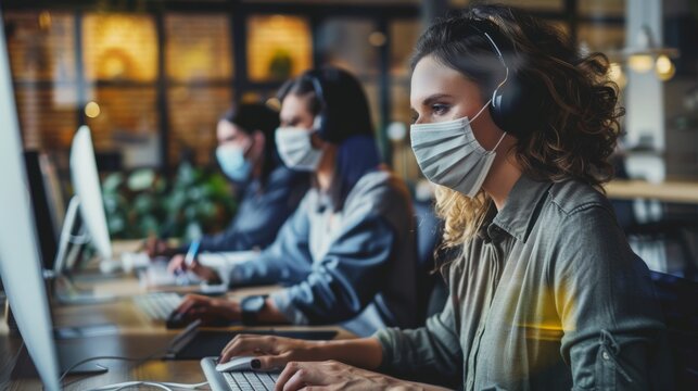 A pair of stylish employees wear protective face masks while working in a loft office, answering emails and managing marketing projects. Pandemic Covid-19 concept. - Powered by Adobe
