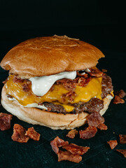 Cheese burger with bacon on black background