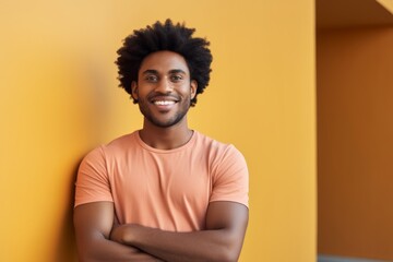 Obraz premium Portrait of a happy afro-american man in his 20s with arms crossed over modern minimalist interior