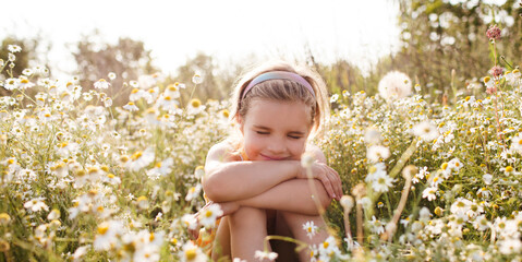 Child girl  sits in a meadow with a  of daisies in summer. Earth Day. World Environment Day. world...