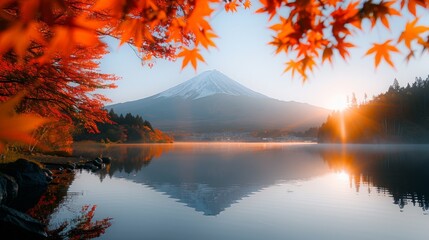 Mt. Fuji reflects in a serene lake framed by fiery red autumn leaves at sunrise, creating a tranquil and picturesque scene.