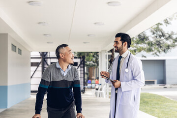 Obraz premium doctor or nurse helping Senior man to walk at nursing home with walker. Doctor or nurse helping old elderly man grandfather to walk using walker equipment