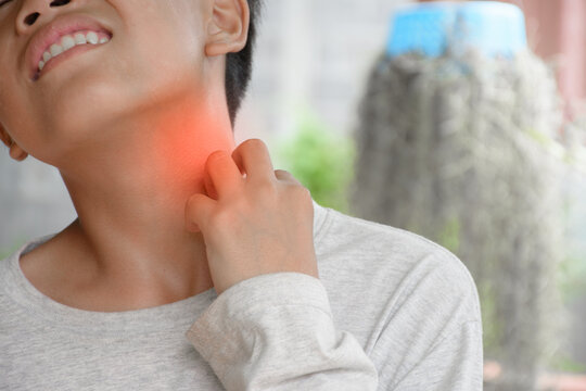 Asian young boy hand touching the neck with a sore throat or coughing and irritation in throat causes of thyroid disease and enlarged lymph nodes for concept of medical and health problems.