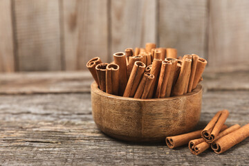 Cinnamon sticks on a textured wooden background. Cinnamon roll. Spicy spice for baking, desserts and drinks. Fragrant ground cinnamon. cinnamon powder Close-up. Place for text. copy space