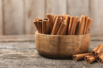 Cinnamon sticks on a textured wooden background. Cinnamon roll. Spicy spice for baking, desserts and drinks. Fragrant ground cinnamon. cinnamon powder Close-up. Place for text. copy space