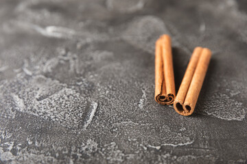 Cinnamon sticks on a textured wooden background. Cinnamon roll. Spicy spice for baking, desserts and drinks. Fragrant ground cinnamon. cinnamon powder Close-up. Place for text. copy space