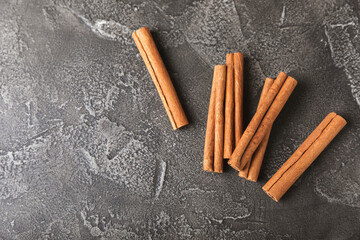 Cinnamon sticks on a textured wooden background. Cinnamon roll. Spicy spice for baking, desserts and drinks. Fragrant ground cinnamon. cinnamon powder Close-up. Place for text. copy space
