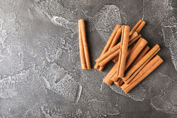 Cinnamon sticks on a textured wooden background. Cinnamon roll. Spicy spice for baking, desserts and drinks. Fragrant ground cinnamon. cinnamon powder Close-up. Place for text. copy space