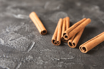 Cinnamon sticks on a textured wooden background. Cinnamon roll. Spicy spice for baking, desserts and drinks. Fragrant ground cinnamon. cinnamon powder Close-up. Place for text. copy space