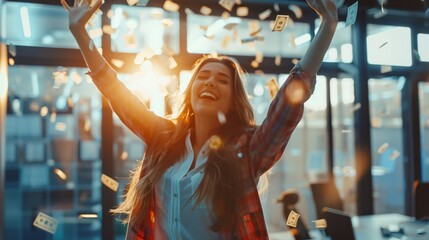 Joyful woman celebrating with money falling around her in a modern office setting