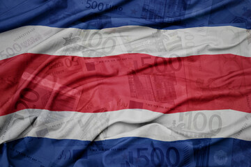 waving colorful national flag of costa rica on a euro money banknotes background. finance concept.